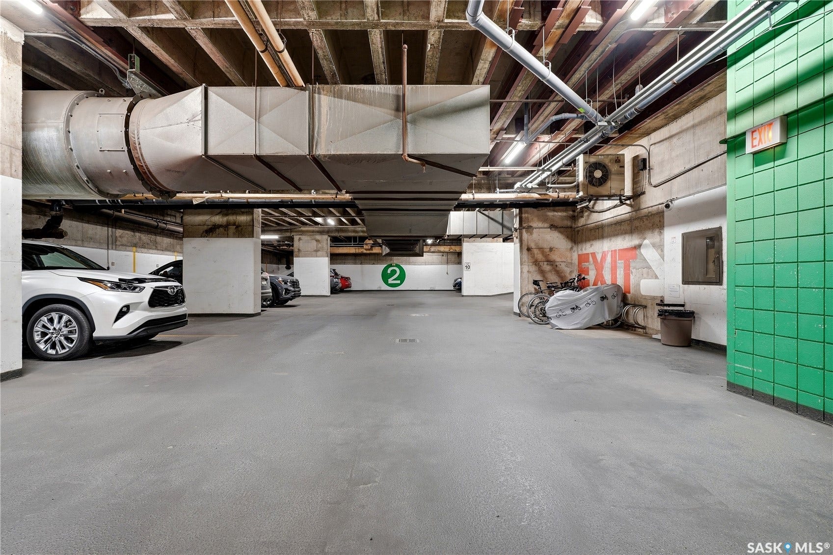 1914 Hamilton Street, #1007, Regina SK S4P 3N6 Concrete flooring in a subterranean parking area with exposed structural beams and overhead ductwork