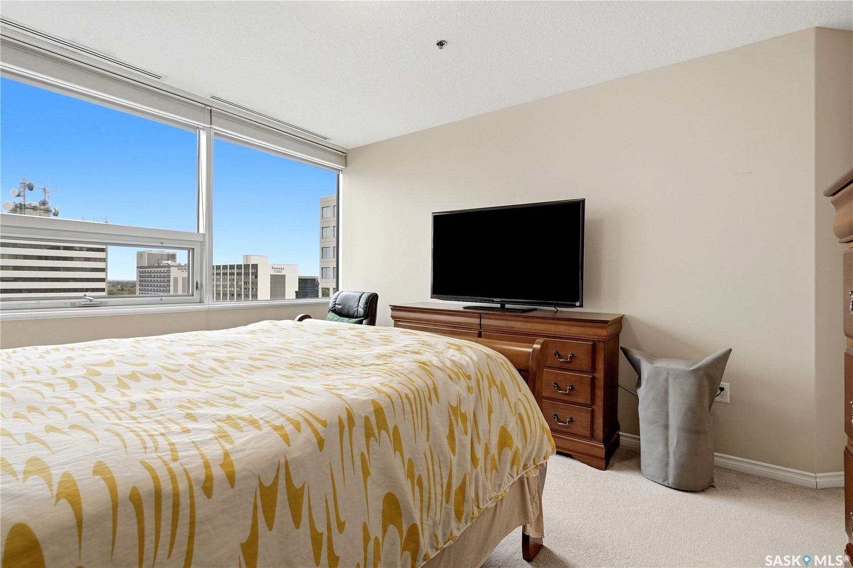 1914 Hamilton Street, #1007, Regina SK S4P 3N6 Expansive window wall with city backdrop, neutral wall finishes, and light-toned carpeting