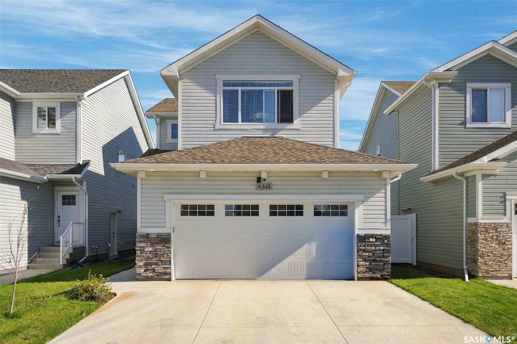 Light-toned siding exterior with stone accents and a two-car garage