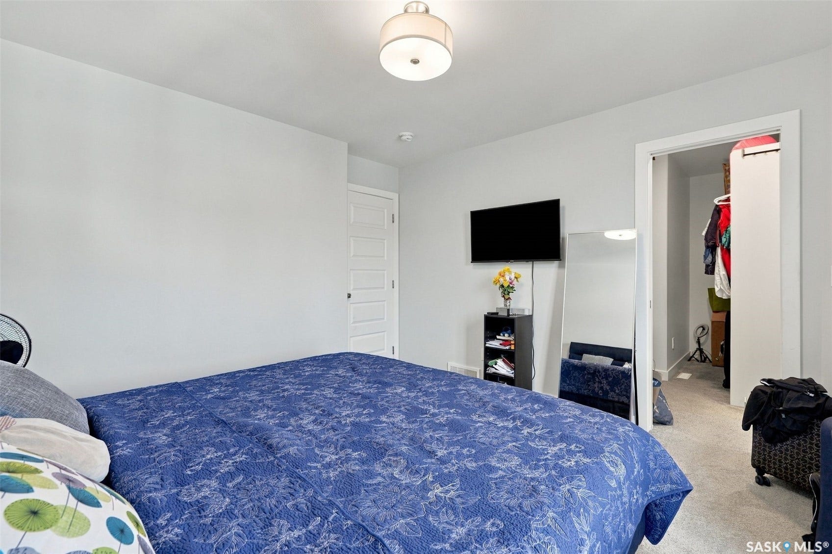 Neutral wall tones, overhead flush-mount lighting, five-panel interior door, and carpeted flooring
