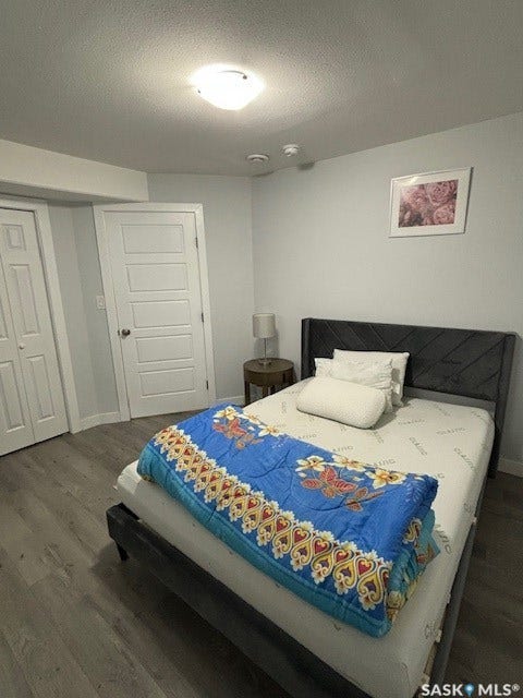 Recessed lighting, wood-finish flooring, white paneled doors, and a decorative headboard
