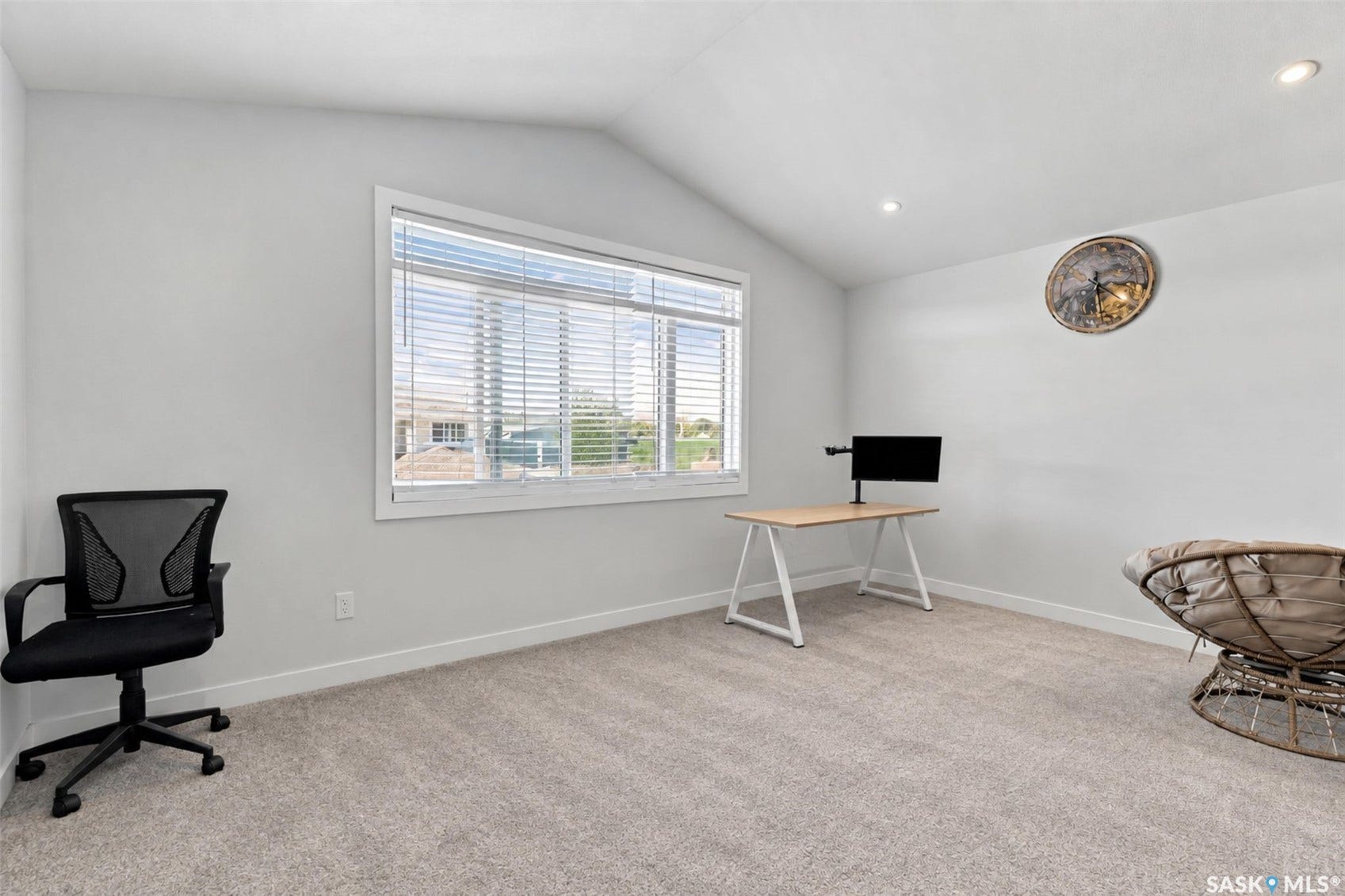 Vaulted ceiling with recessed lighting, large window with blinds, and light-toned carpet flooring