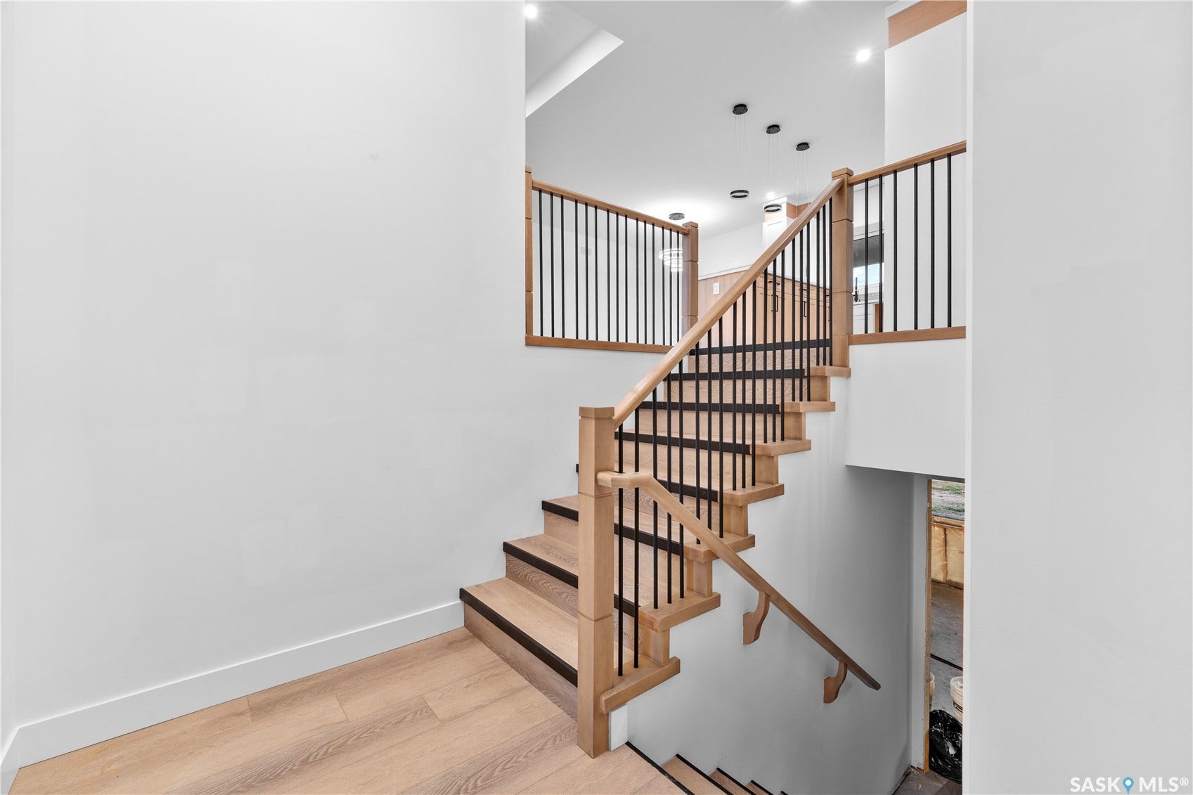 12 Elkwood Cove, Dundurn Rm No SK S7C 0C5 Modern staircase with light wood-finish treads, black risers, and black metal balusters
