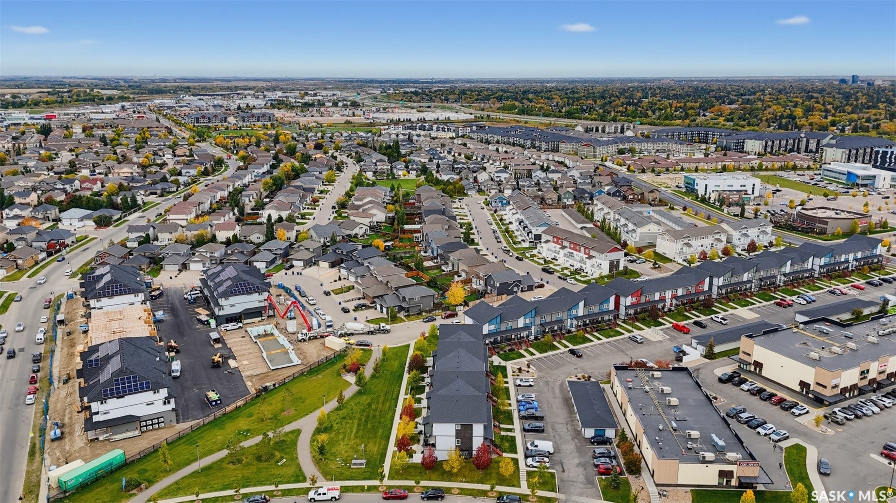 Expansive aerial depicting a residential neighborhood with diverse architectural styles, including modern townhomes and single-family residences