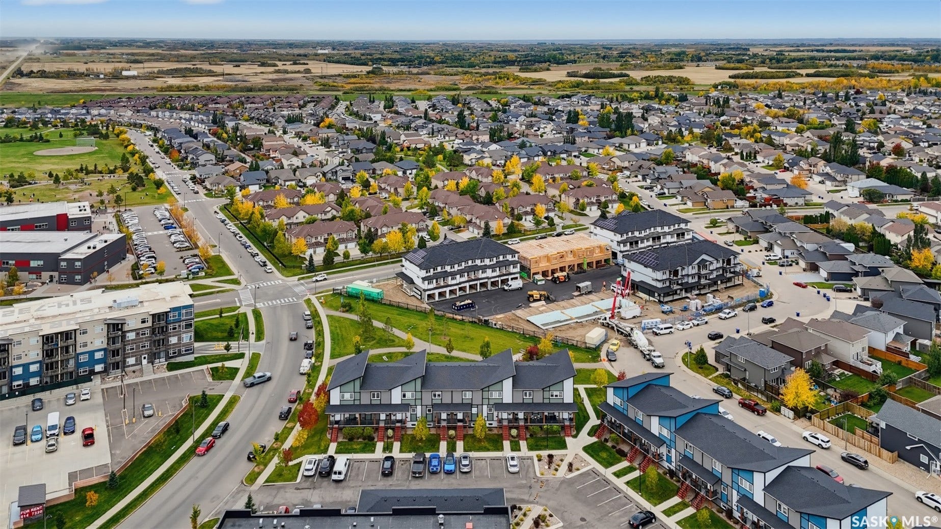 Expansive aerial perspective showcasing a developed residential area with established homes, tree-lined streets, and open green spaces