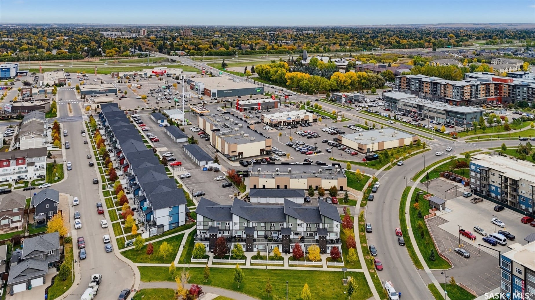 Contemporary townhome community with a tree-lined streetscape and adjacent commercial establishments