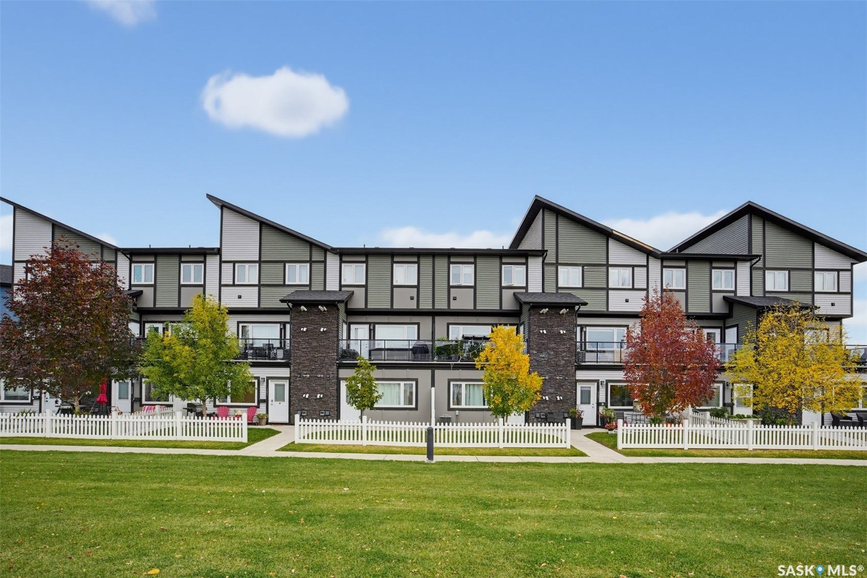 Contemporary townhome exterior featuring an asymmetrical roofline and a combination of horizontal siding and stone accents