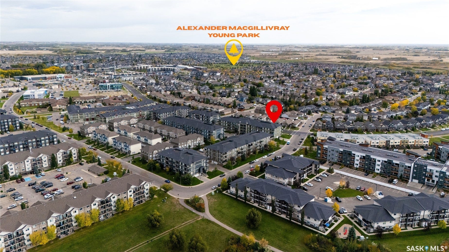 Aerial perspective of a developed residential area with numerous buildings, green spaces, and a designated park area