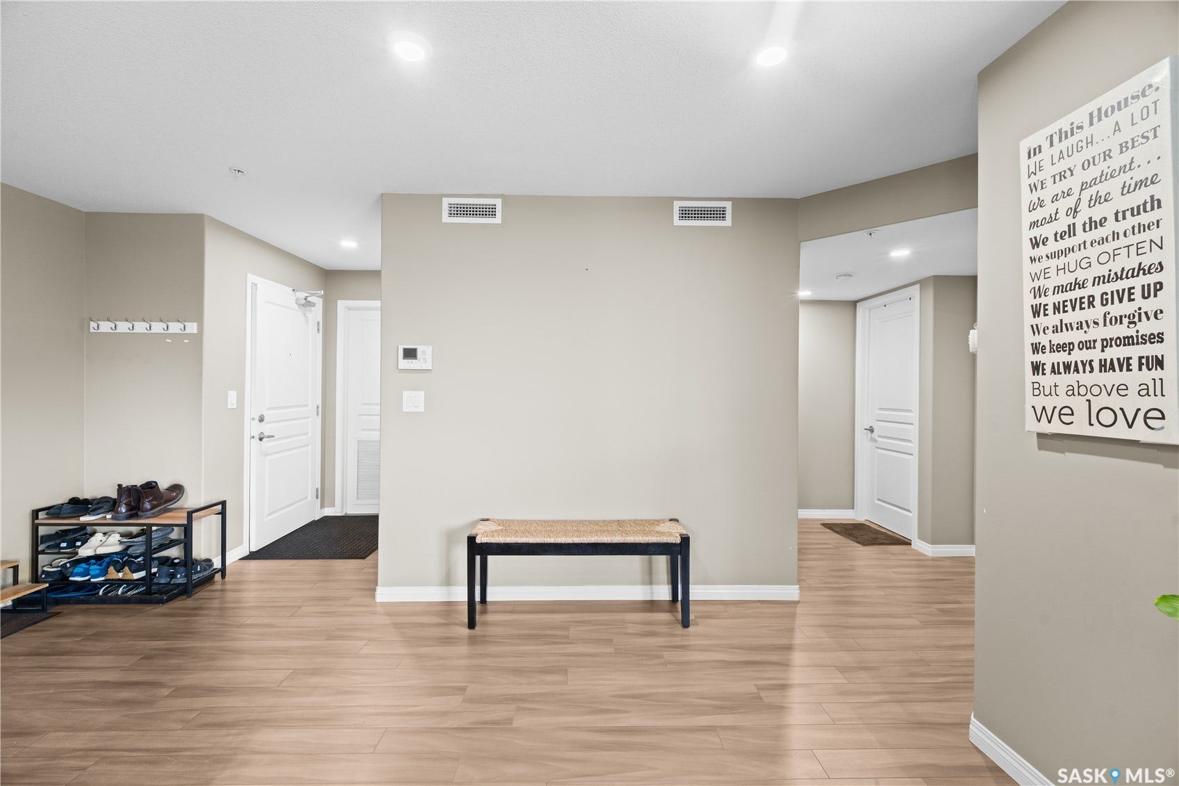 Recessed lighting, wood-finish flooring, light neutral wall paint, white trim, and white paneled doors