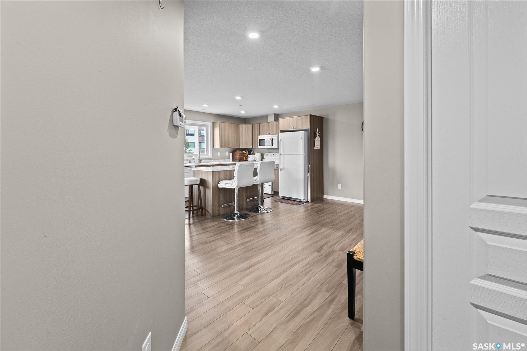 Kitchen featuring wood-finish flooring, recessed lighting, and a kitchen island with seating