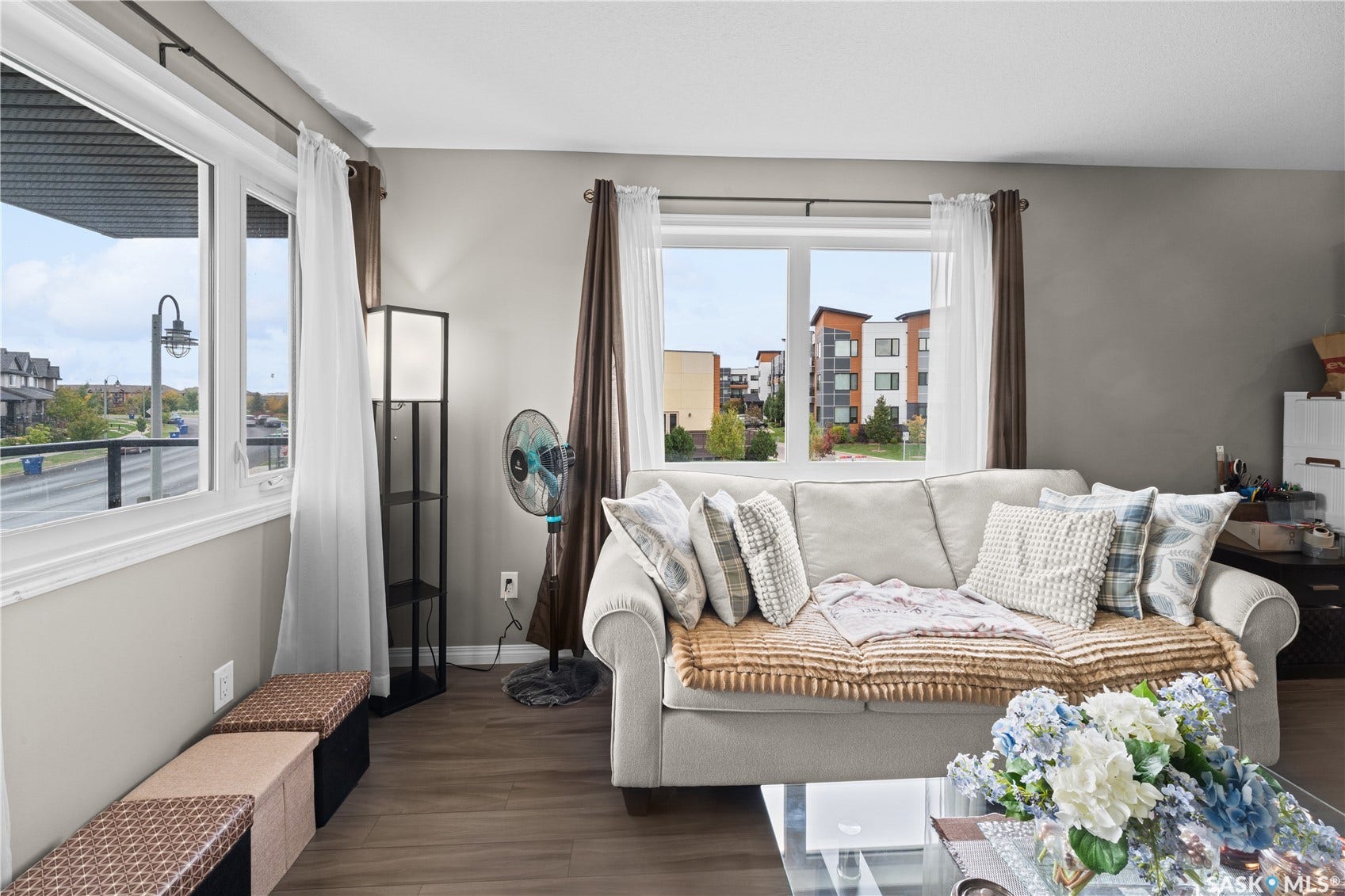 Wall-to-wall wood-finish flooring, neutral paint palette, and white window trim