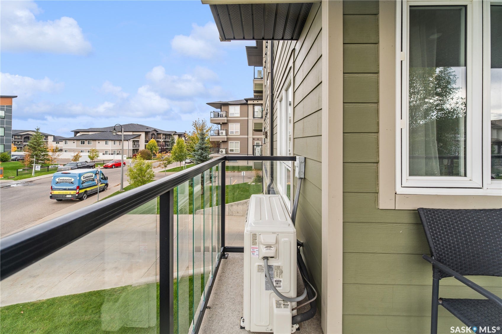 Balcony featuring glass panel railing, durable siding, and white window trim