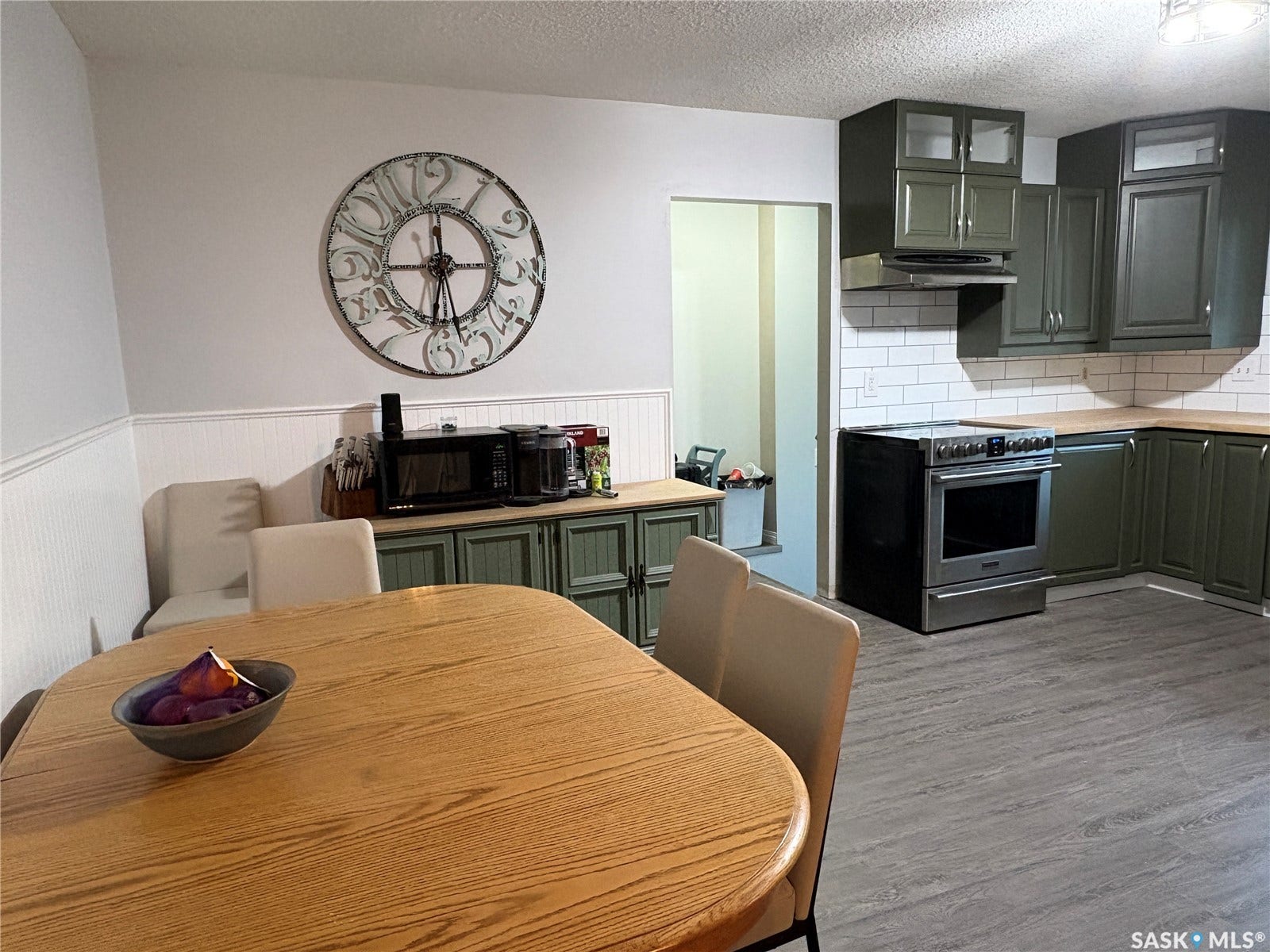 Kitchen featuring wood-finish flooring, wood countertops, subway tile backsplash, and olive green cabinetry
