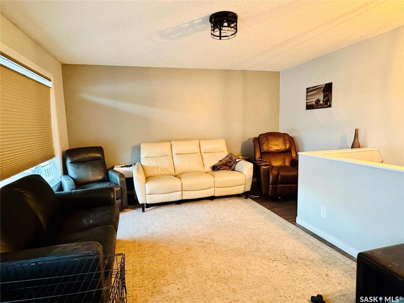 Recessed window with privacy blinds, overhead caged light fixture, and wood-finish flooring