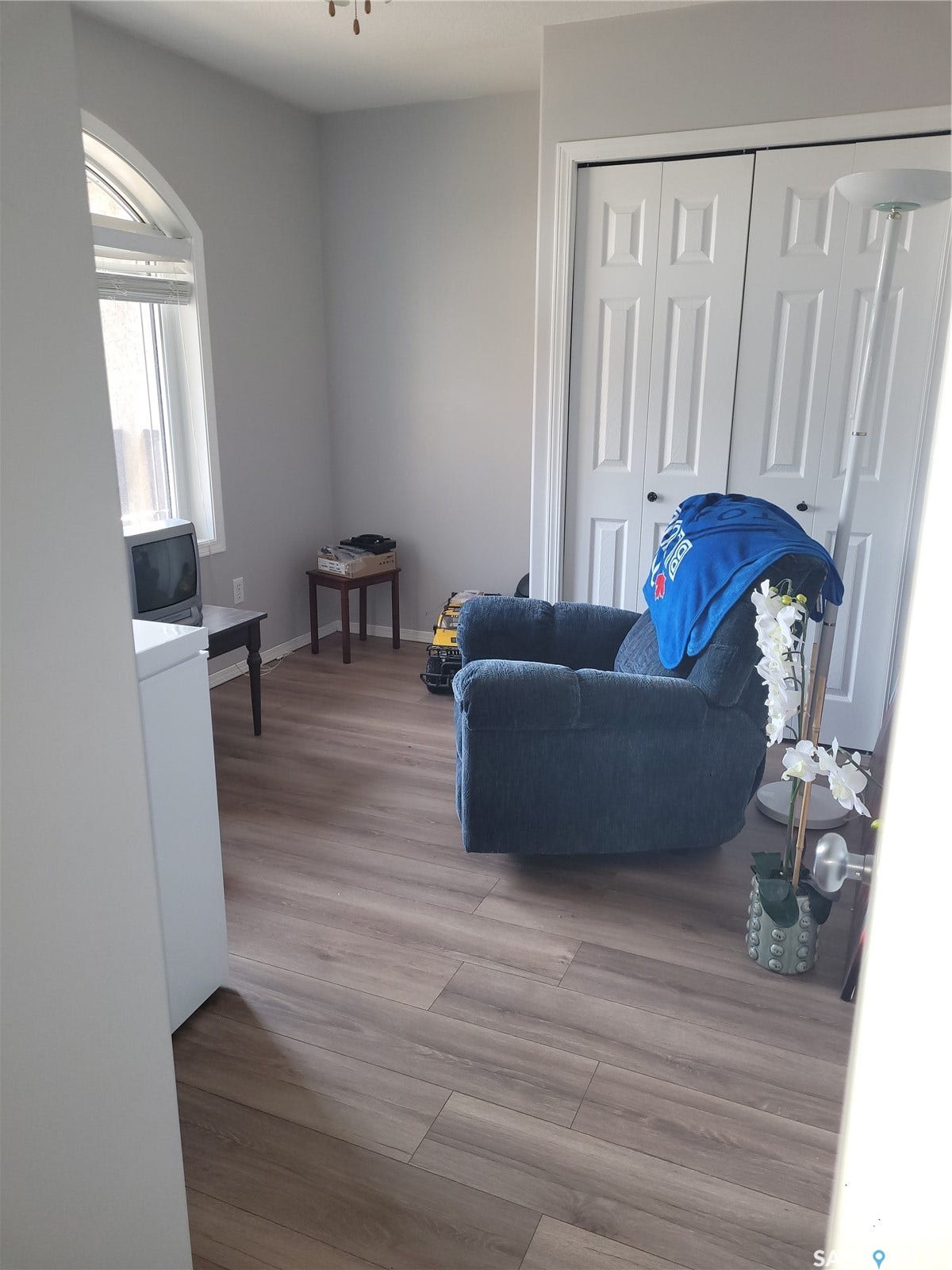 Wood-finish flooring throughout, arched window, and bi-fold closet doors