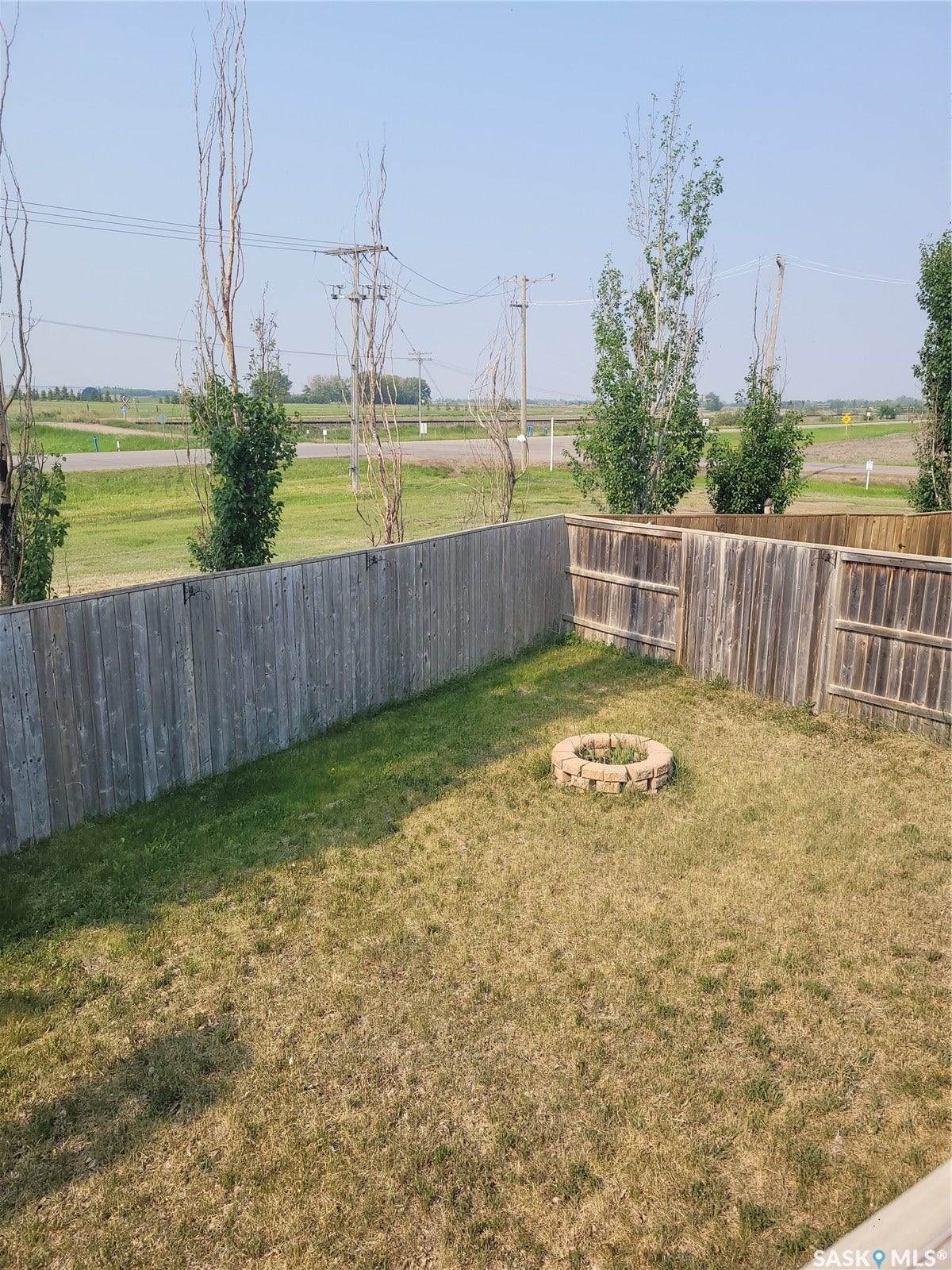 Fenced backyard with a stone-lined fire pit