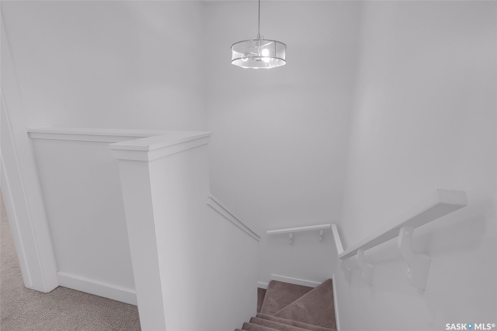 Staircase with carpeted treads, white painted handrails, and a contemporary drum light fixture