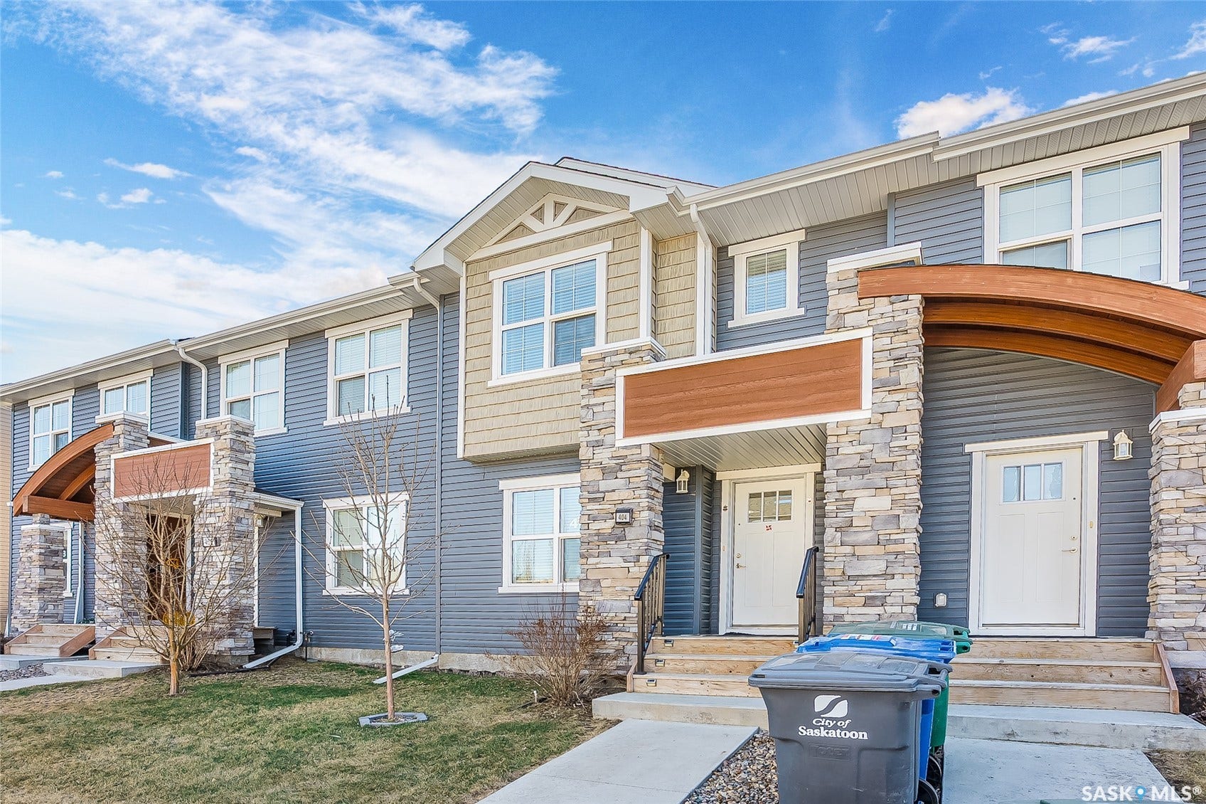 Exterior featuring stone accents, blue siding, wood-finish gables, and white-framed windows
