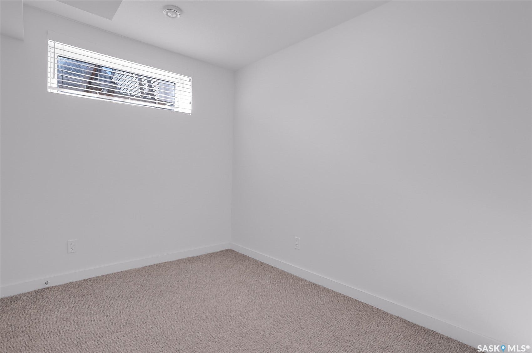 Recessed lighting, horizontal window blinds, and neutral carpeting