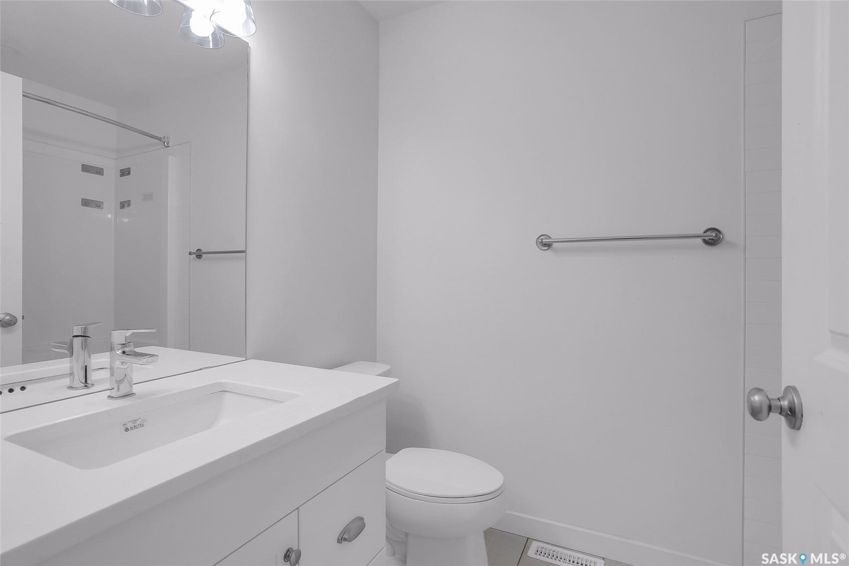 White vanity with integrated sink, chrome faucet, and under-vanity storage