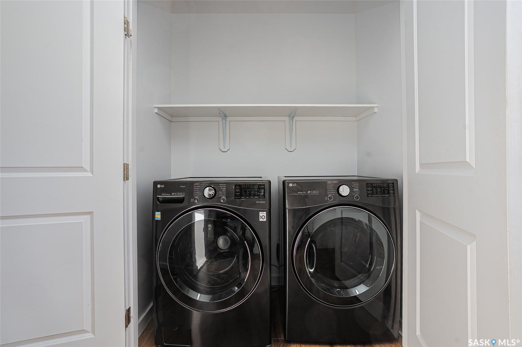 Laundry area featuring a built-in shelf and panel doors