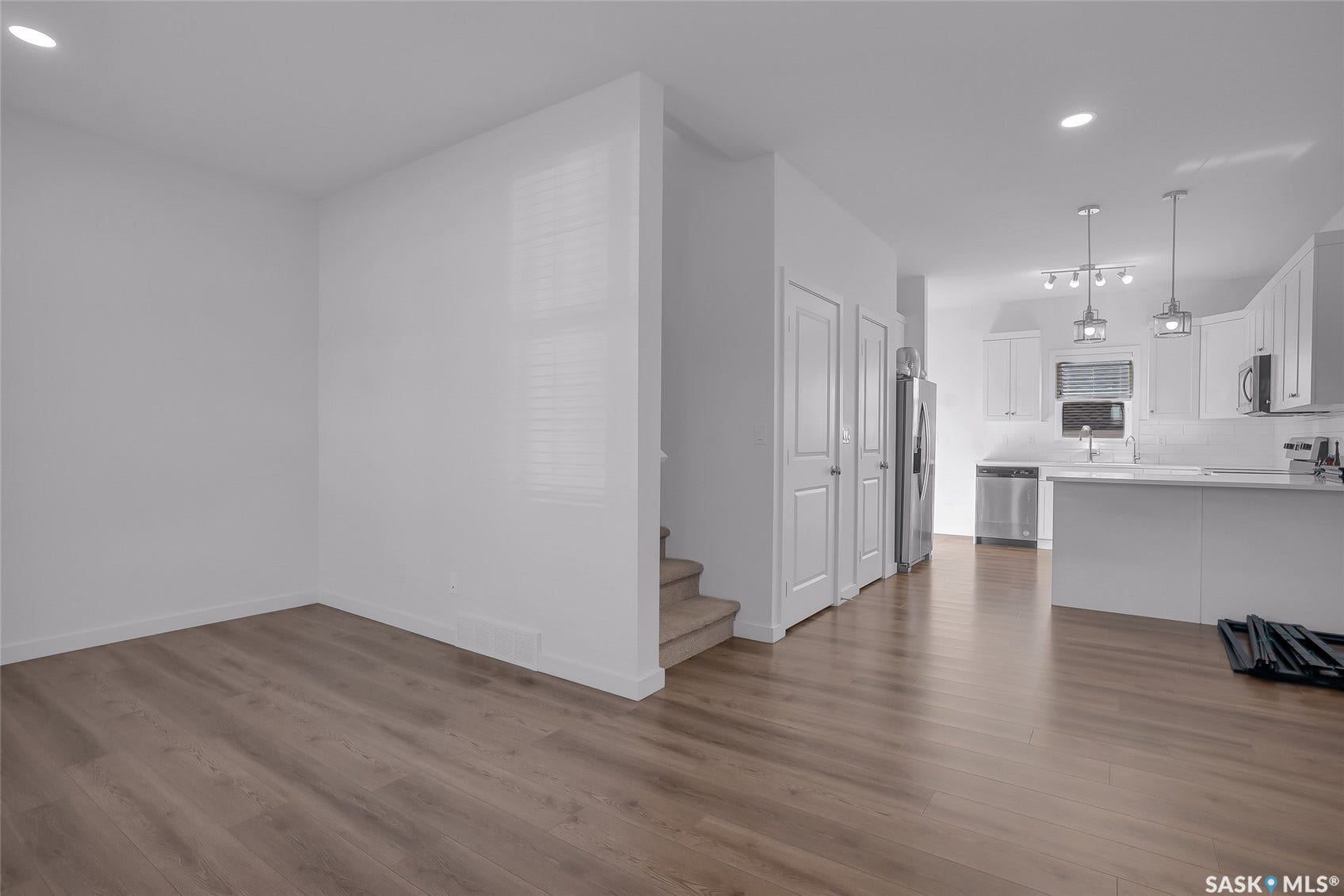 Wood-finish flooring throughout, white walls, and recessed lighting