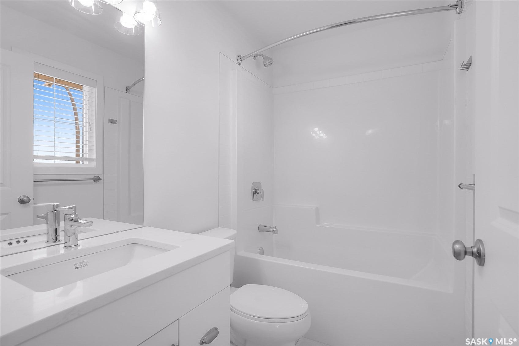White vanity with an integrated sink, polished chrome faucet, and a large wall-mounted mirror