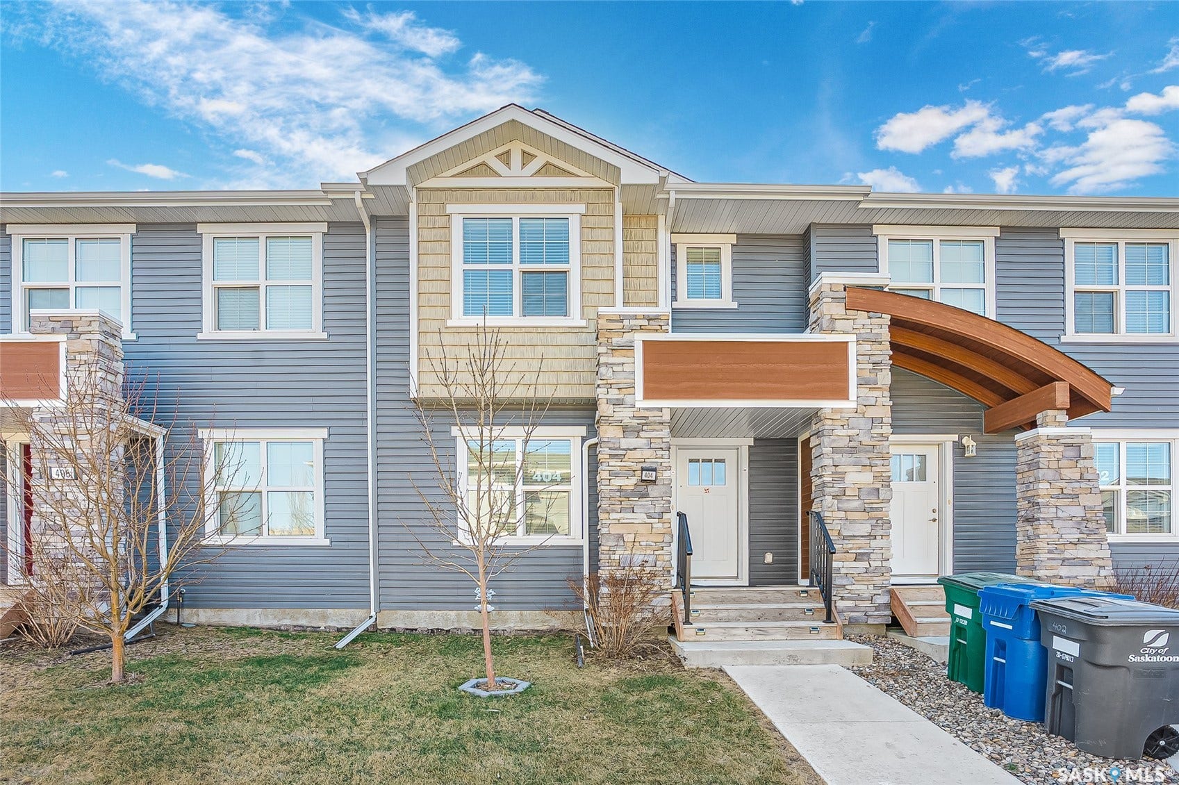 Multi-level exterior featuring horizontal siding, stone veneer accents, and multiple windows with white trim