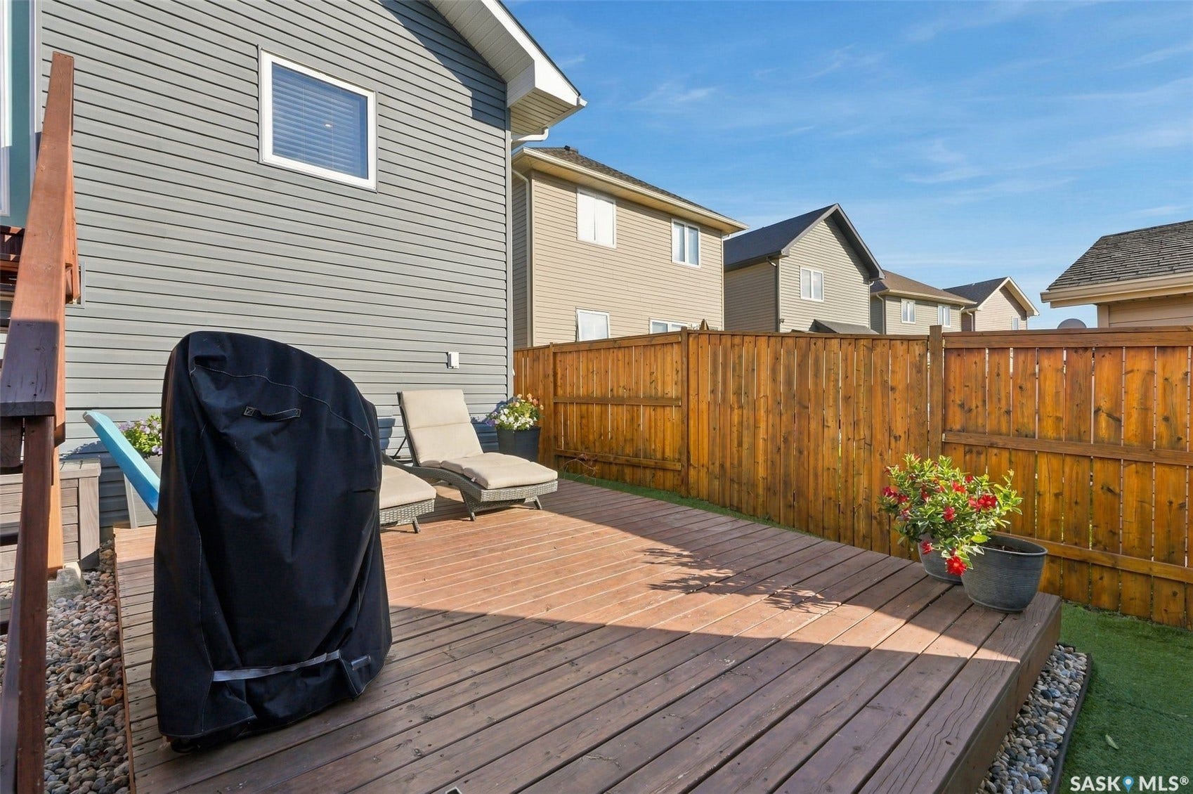919 Kolynchuk Bend, Saskatoon SK S7T 0V9 Outdoor wooden deck with privacy fencing and artificial turf