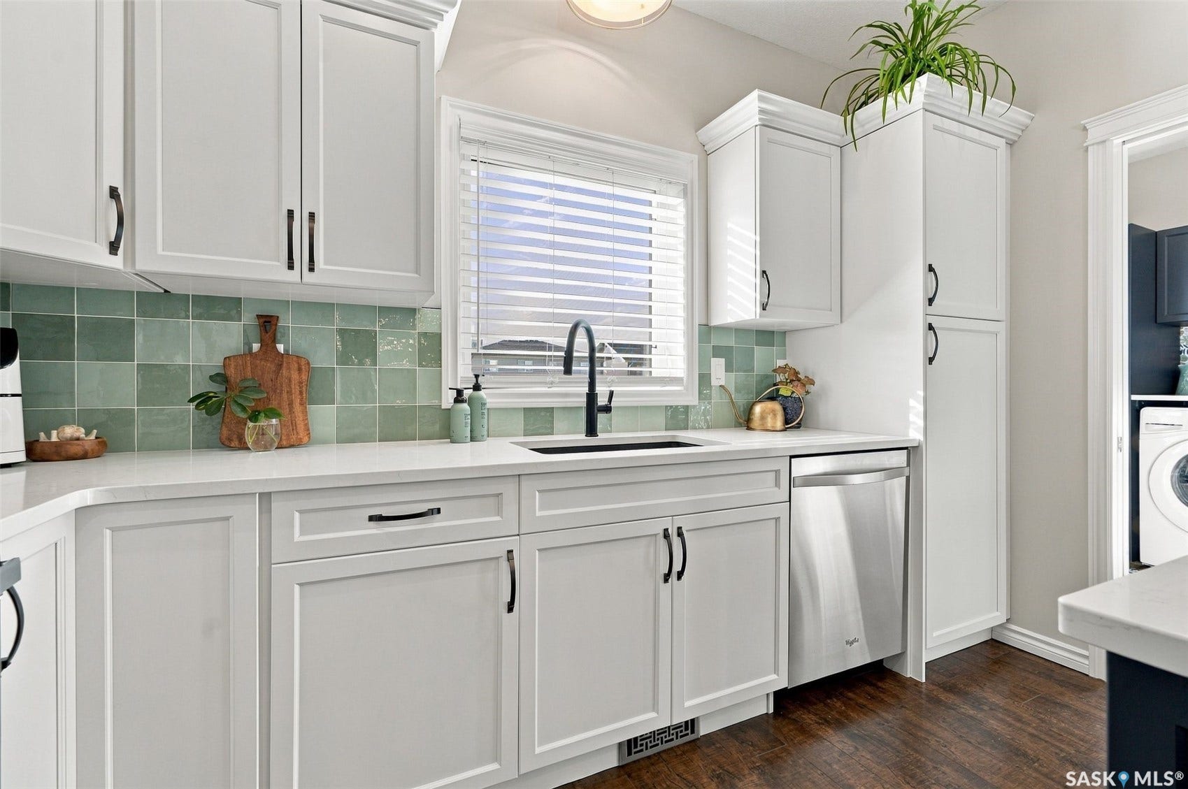 919 Kolynchuk Bend, Saskatoon SK S7T 0V9 White shaker cabinetry with black hardware, light-toned countertops, and a green tile backsplash