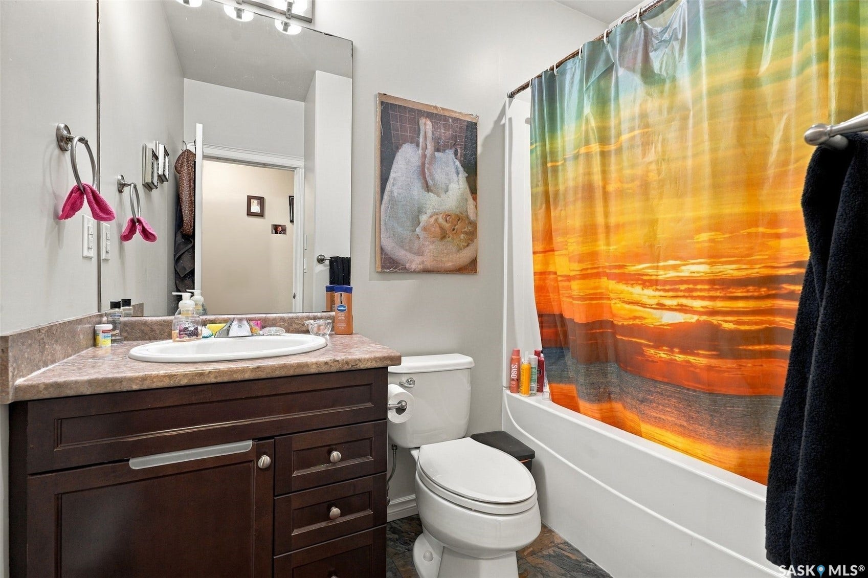 919 Kolynchuk Bend, Saskatoon SK S7T 0V9 Bathroom featuring a dark wood-finish vanity with a surface-mount sink, speckled countertop, and a built-in bathtub with shower