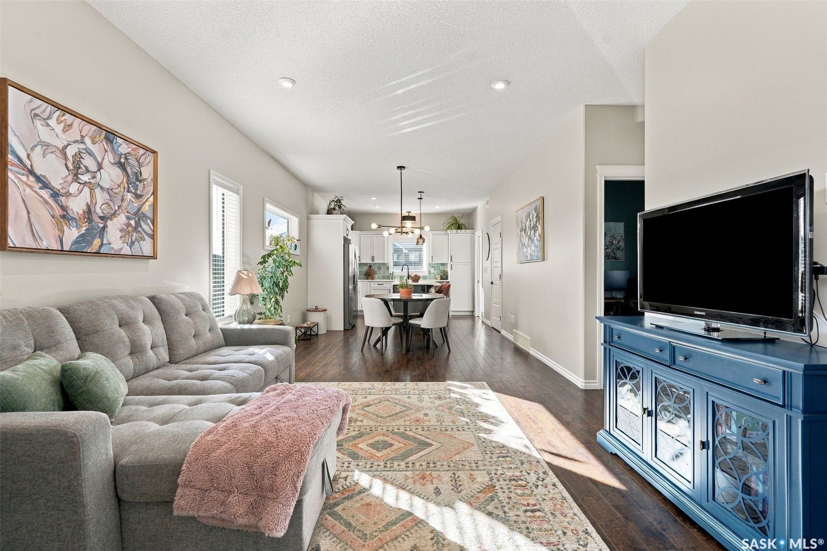 919 Kolynchuk Bend, Saskatoon SK S7T 0V9 Open-concept living space with dark wood-finish flooring, recessed lighting, and white trim