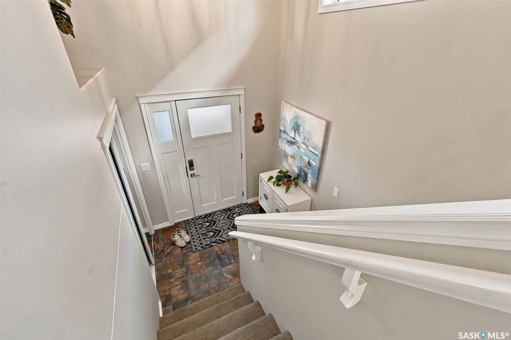 919 Kolynchuk Bend, Saskatoon SK S7T 0V9 Entryway with multi-pane door, textured glass sidelight, and slate-finish tile flooring