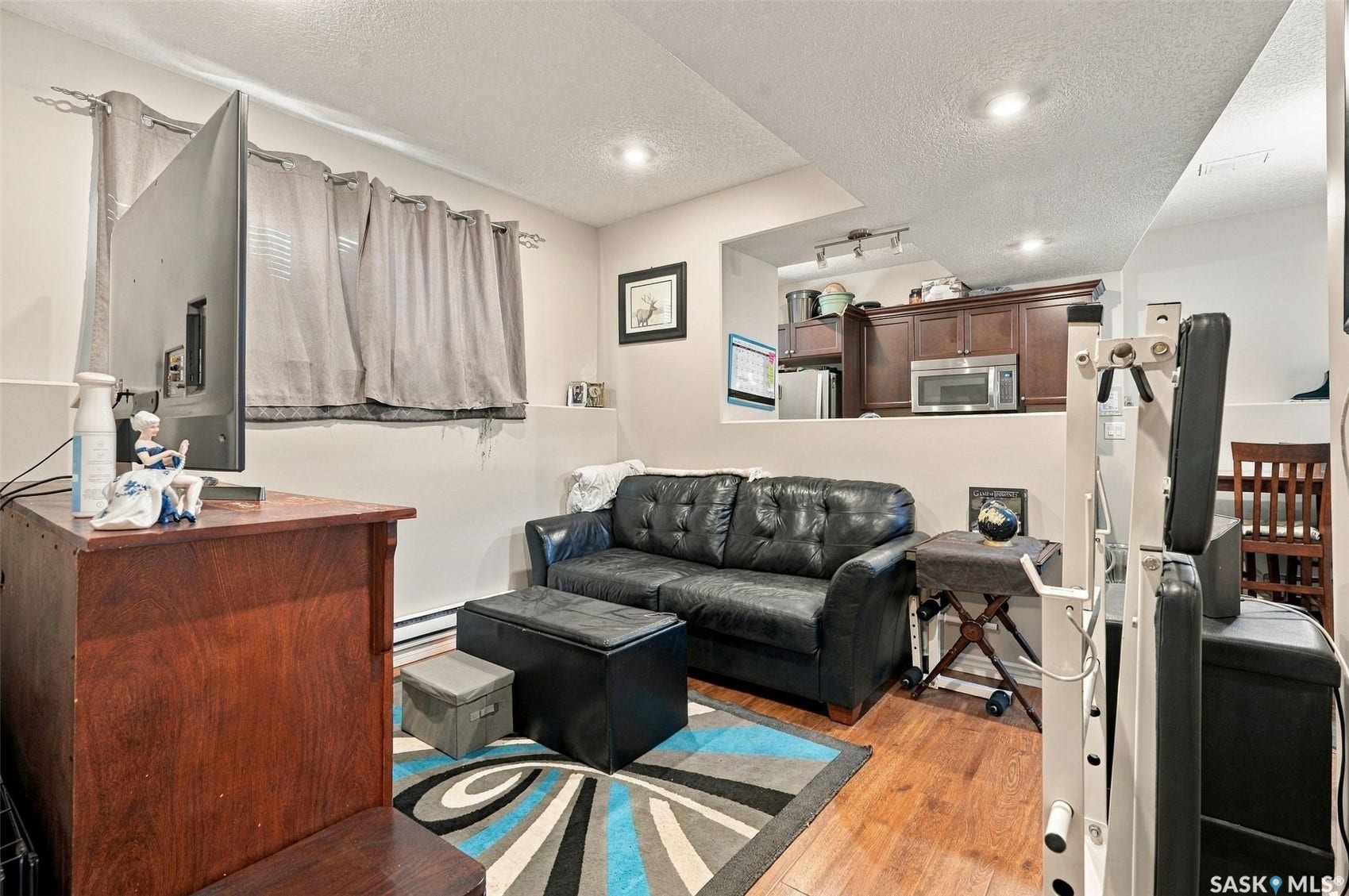 919 Kolynchuk Bend, Saskatoon SK S7T 0V9 Wood-finish flooring, recessed lighting, and a built-in counter with cabinetry and a stainless steel microwave