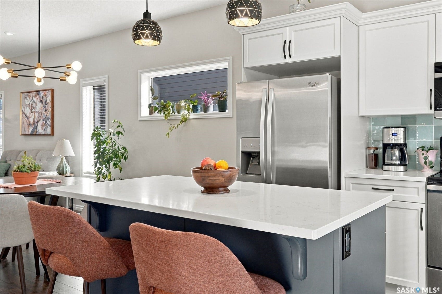 919 Kolynchuk Bend, Saskatoon SK S7T 0V9 Kitchen featuring white upper cabinetry, stainless steel refrigerator, white countertops, and a blue subway tile backsplash