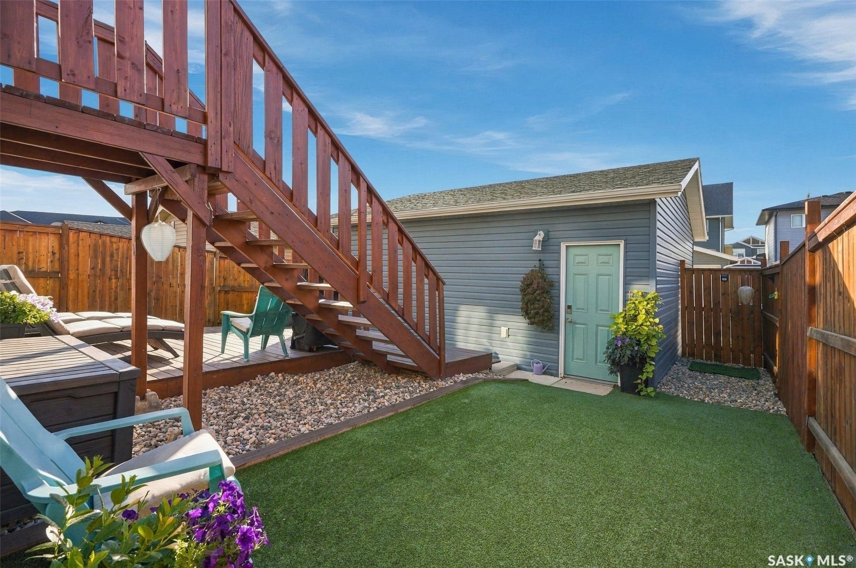 919 Kolynchuk Bend, Saskatoon SK S7T 0V9 Expansive outdoor decking, artificial turf, durable wood fencing, and a detached structure with siding
