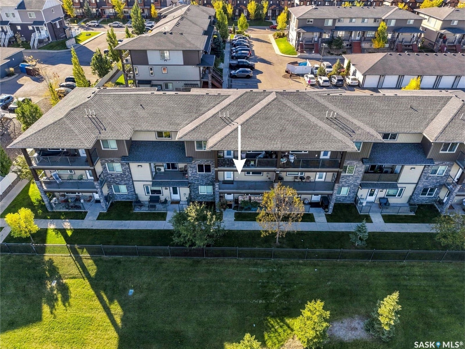 Multi-level building with stone accent siding, private balconies, and ground-level patios