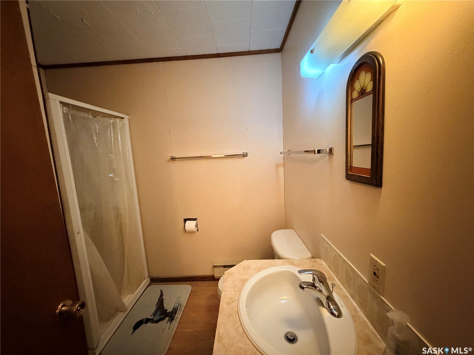 Vanity with an oval sink and chrome faucet, tile backsplash, and a wall-mounted mirror