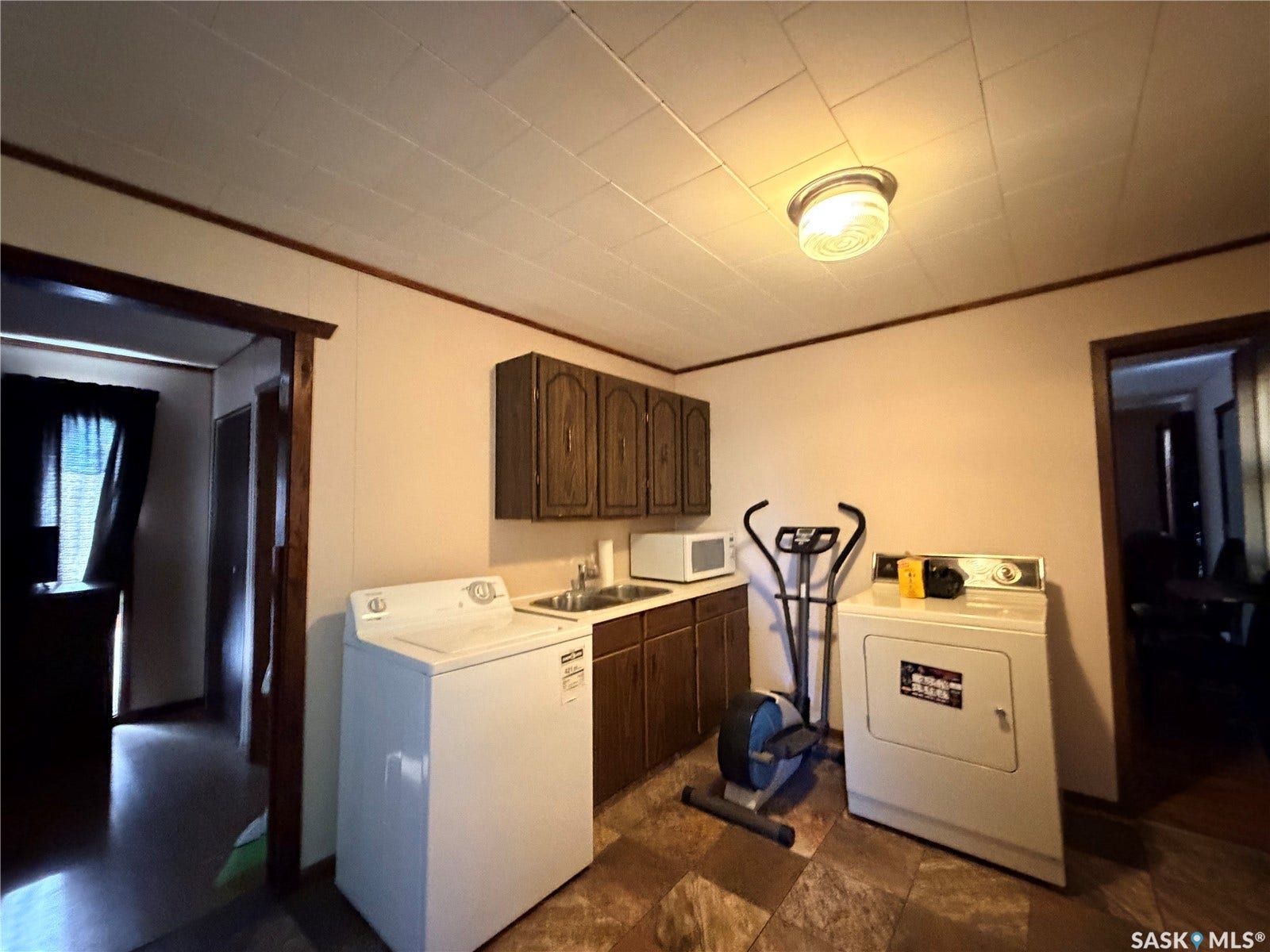 Built-in cabinetry with wood-finish doors, durable countertop, and flush-mount ceiling lighting