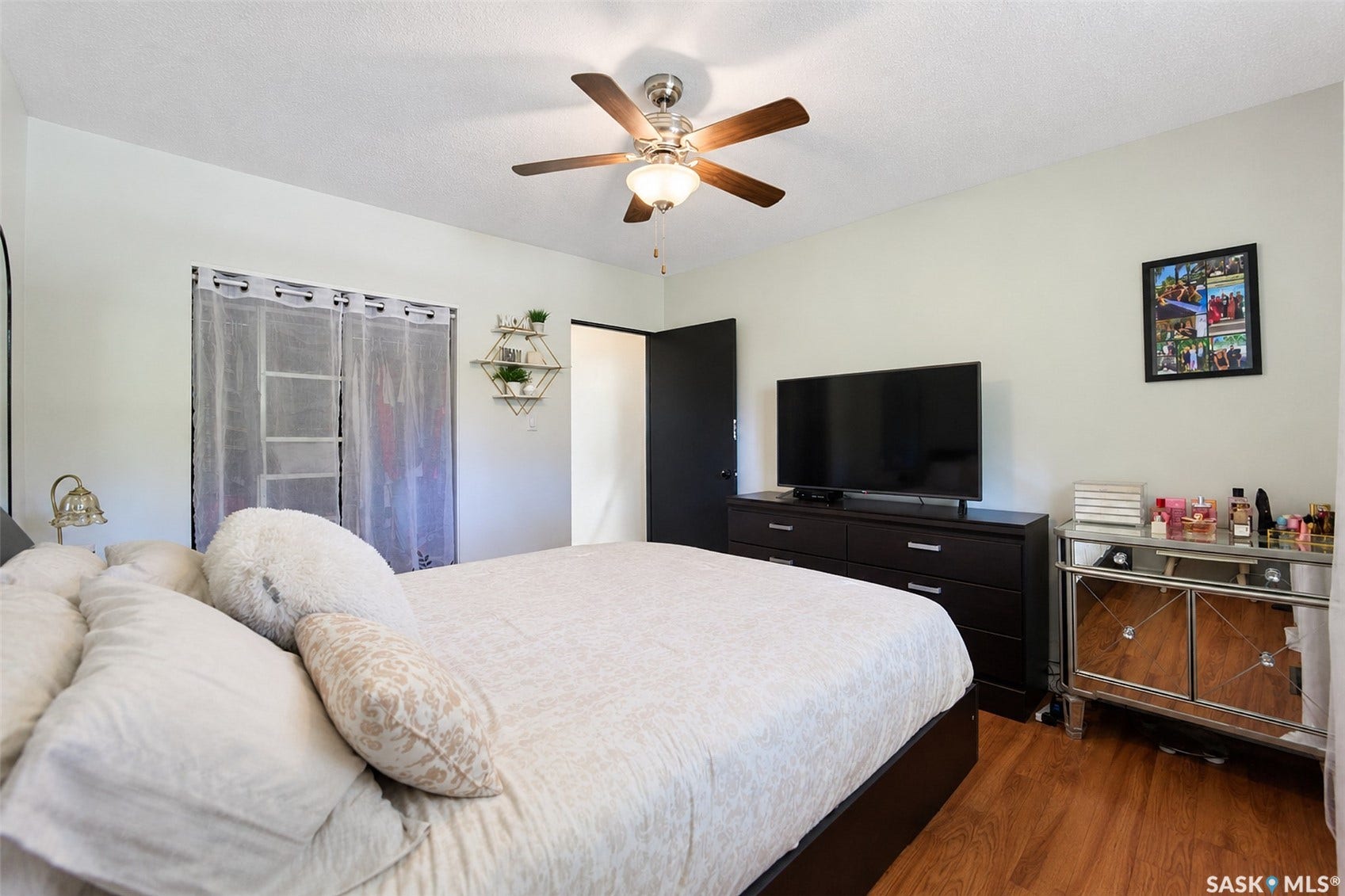 Wood-finish flooring with a ceiling fan and overhead lighting