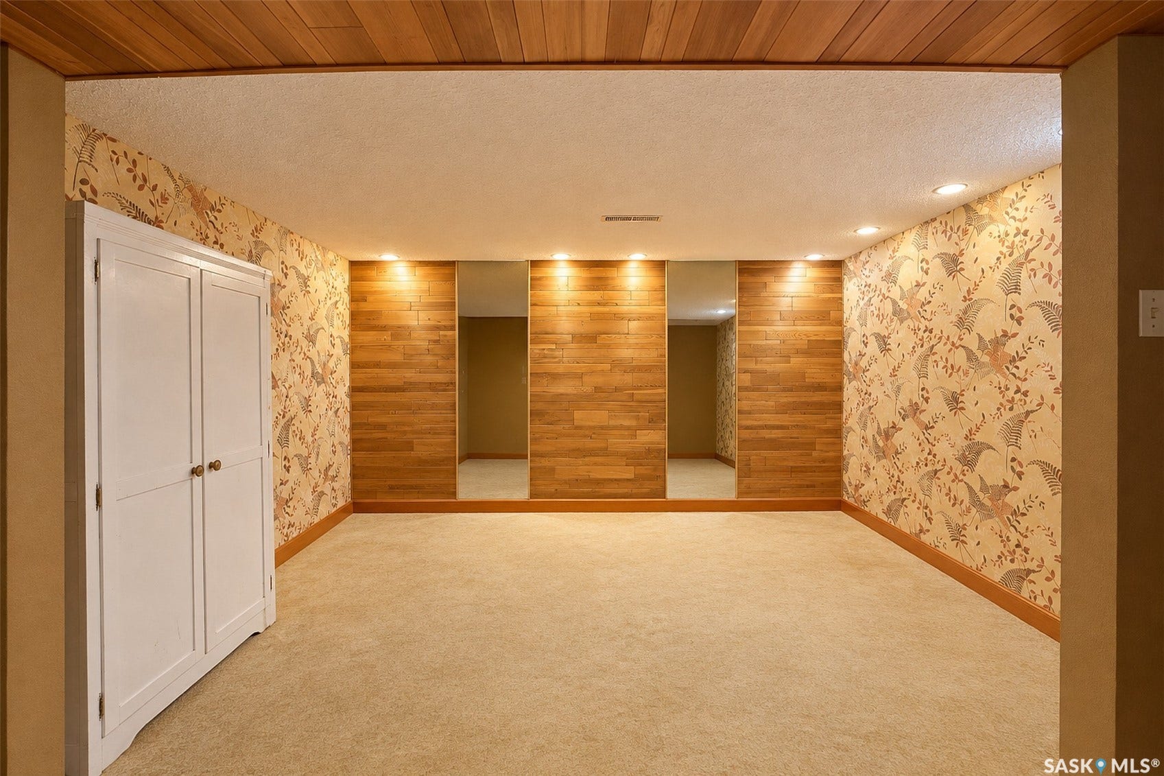 Wood-paneled ceiling, recessed lighting, and wall-mounted mirrors