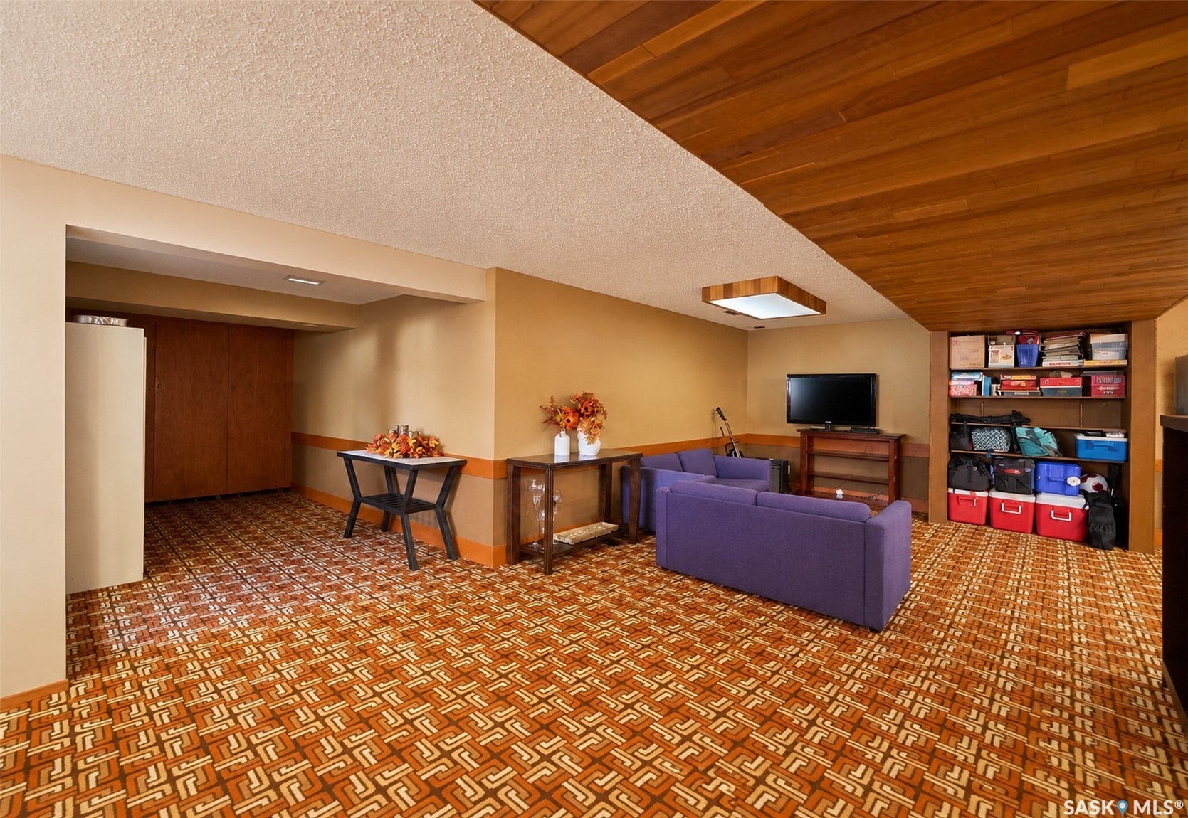Wood panel ceiling, recessed lighting, built-in shelving, wood-finish cabinetry, patterned carpet