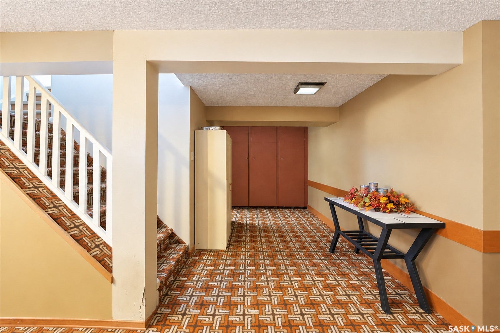 Patterned flooring throughout, with a coordinated carpeted staircase and white balusters