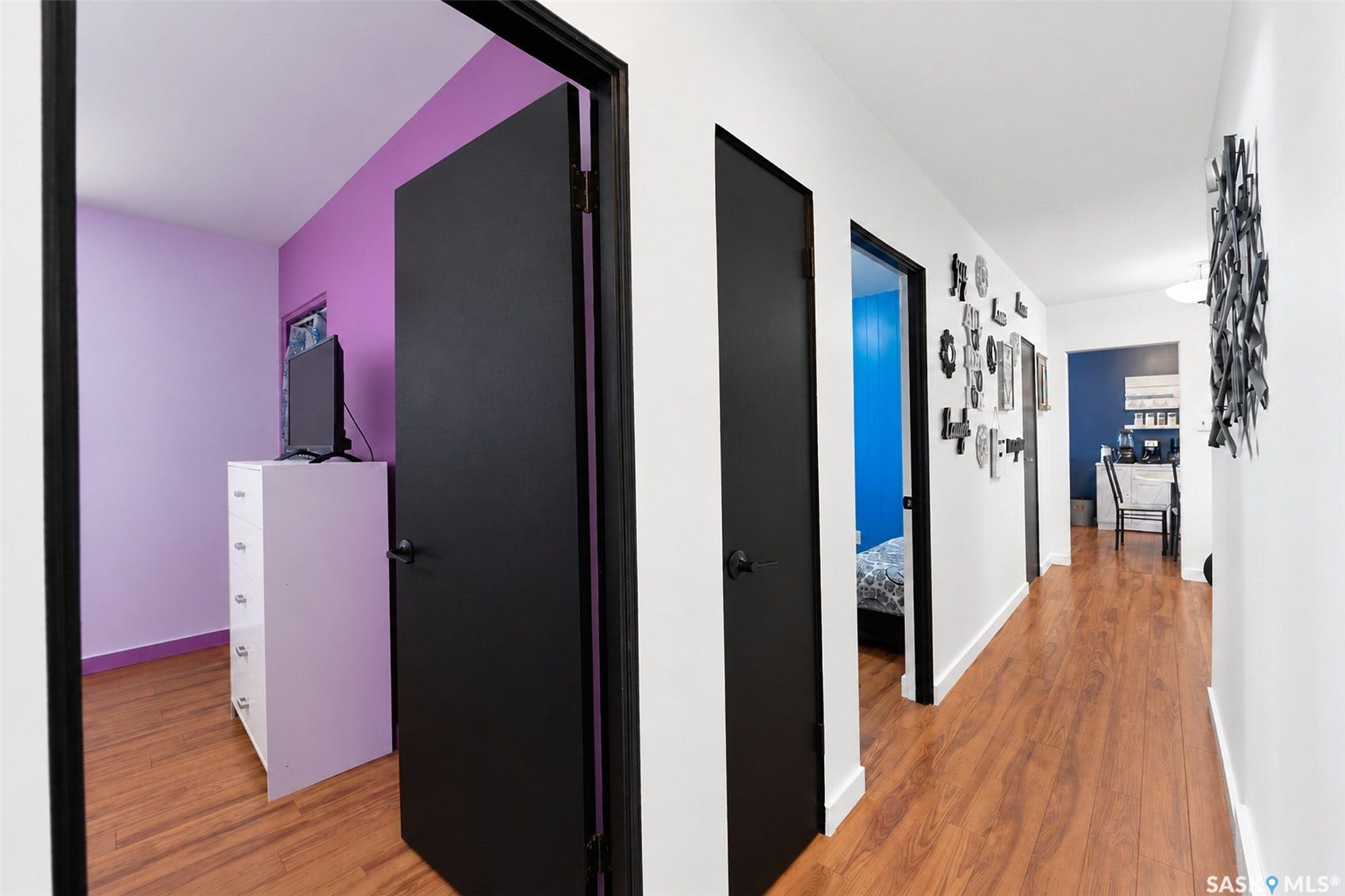 Wood-finish flooring throughout, white walls, and black interior doors