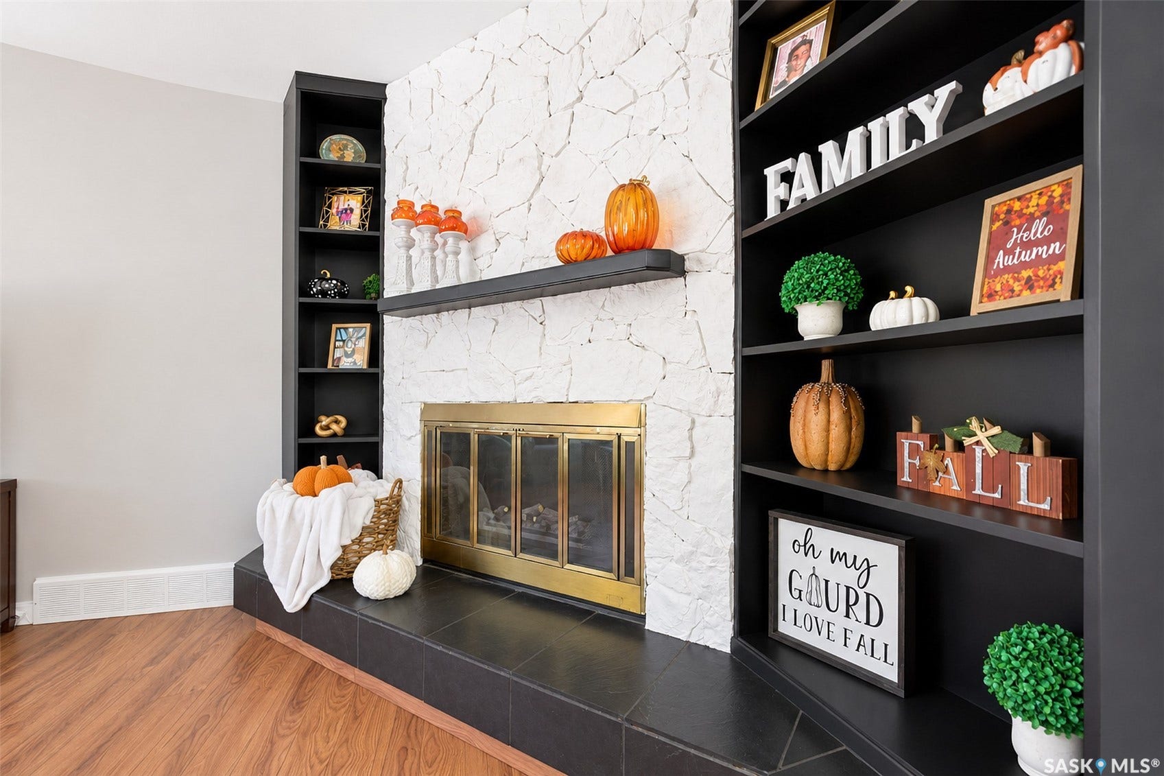 Fireplace featuring a stone facade, mantel, and a brass-framed firebox