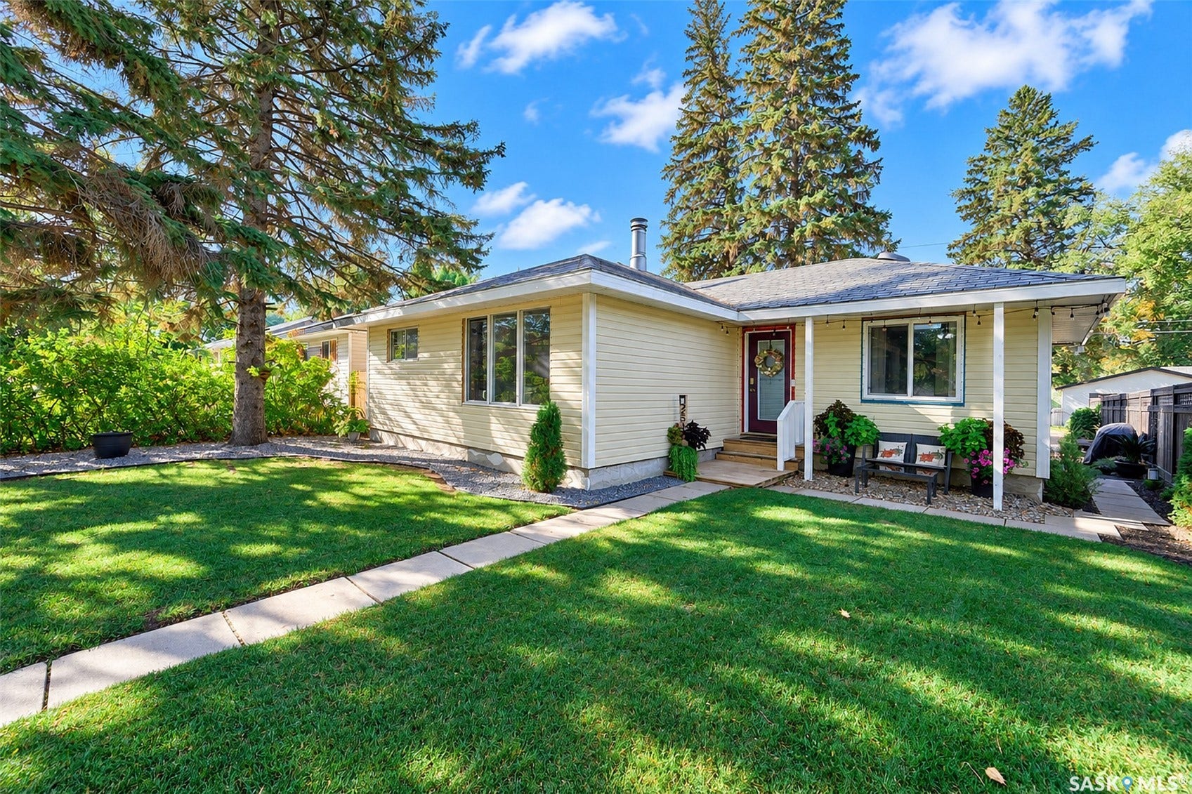 Ranch-style exterior with light-colored siding, a covered front entry, and a paved walkway