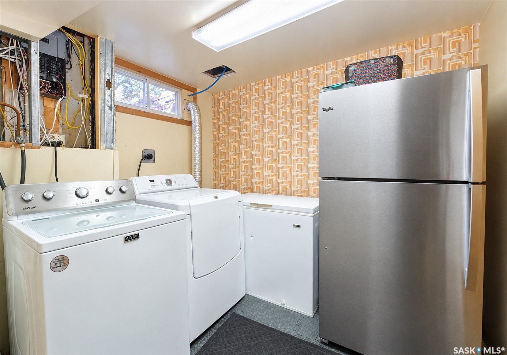 Laundry area featuring a top-load washer, front-load dryer, and a small window