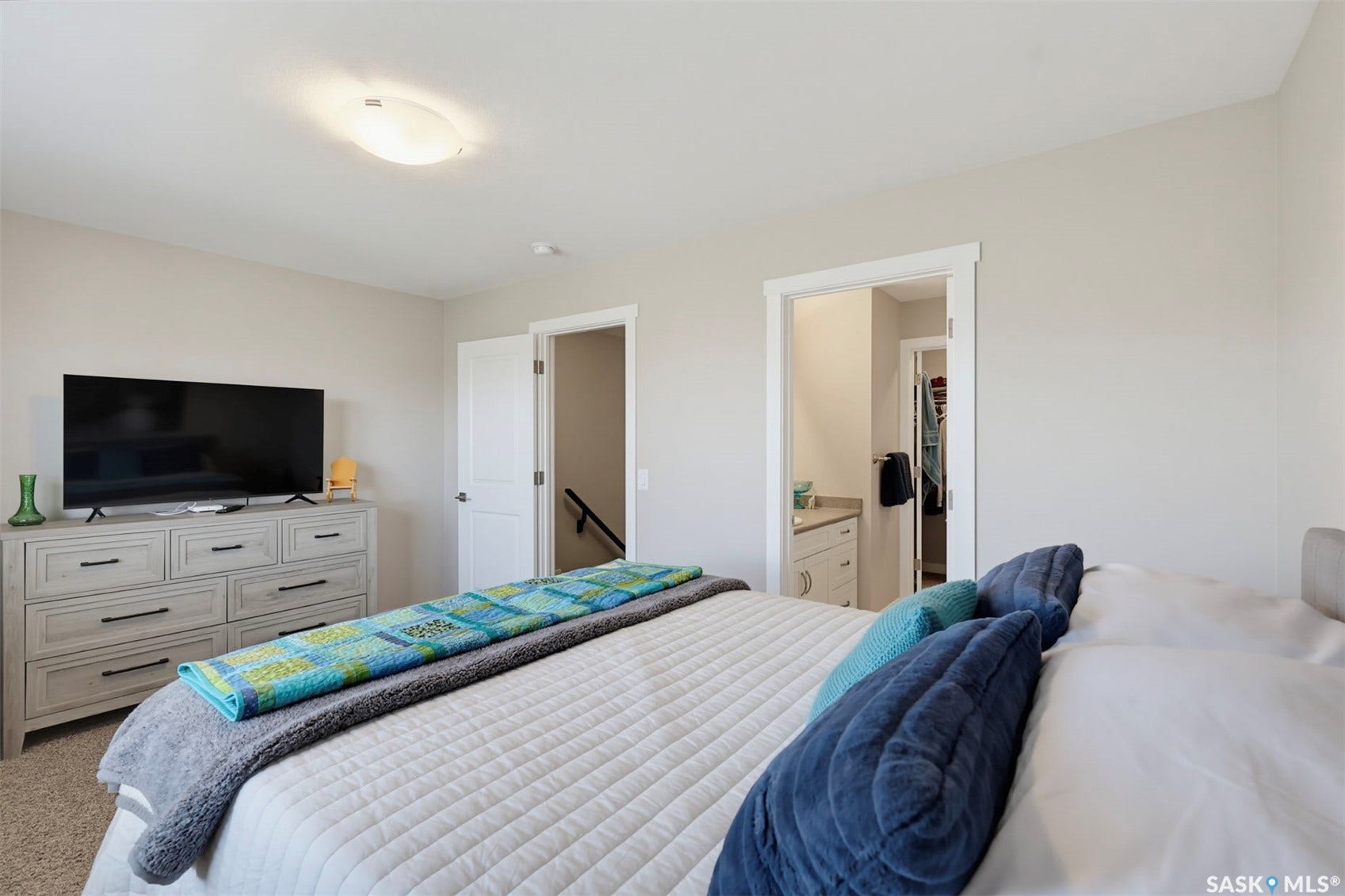 Plush carpeting and light-colored walls create a neutral palette