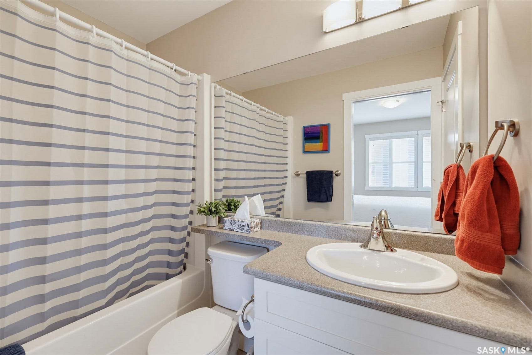 Vanity with an integrated sink, brushed nickel faucet, and extensive mirror