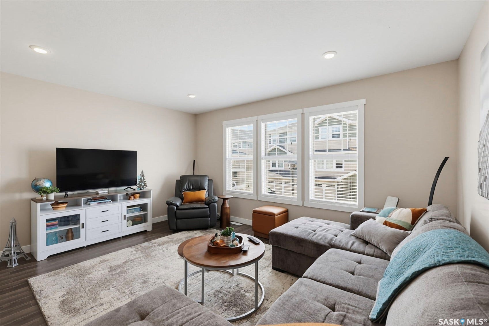 Recessed lighting, wood-finish flooring, and multiple windows with blinds